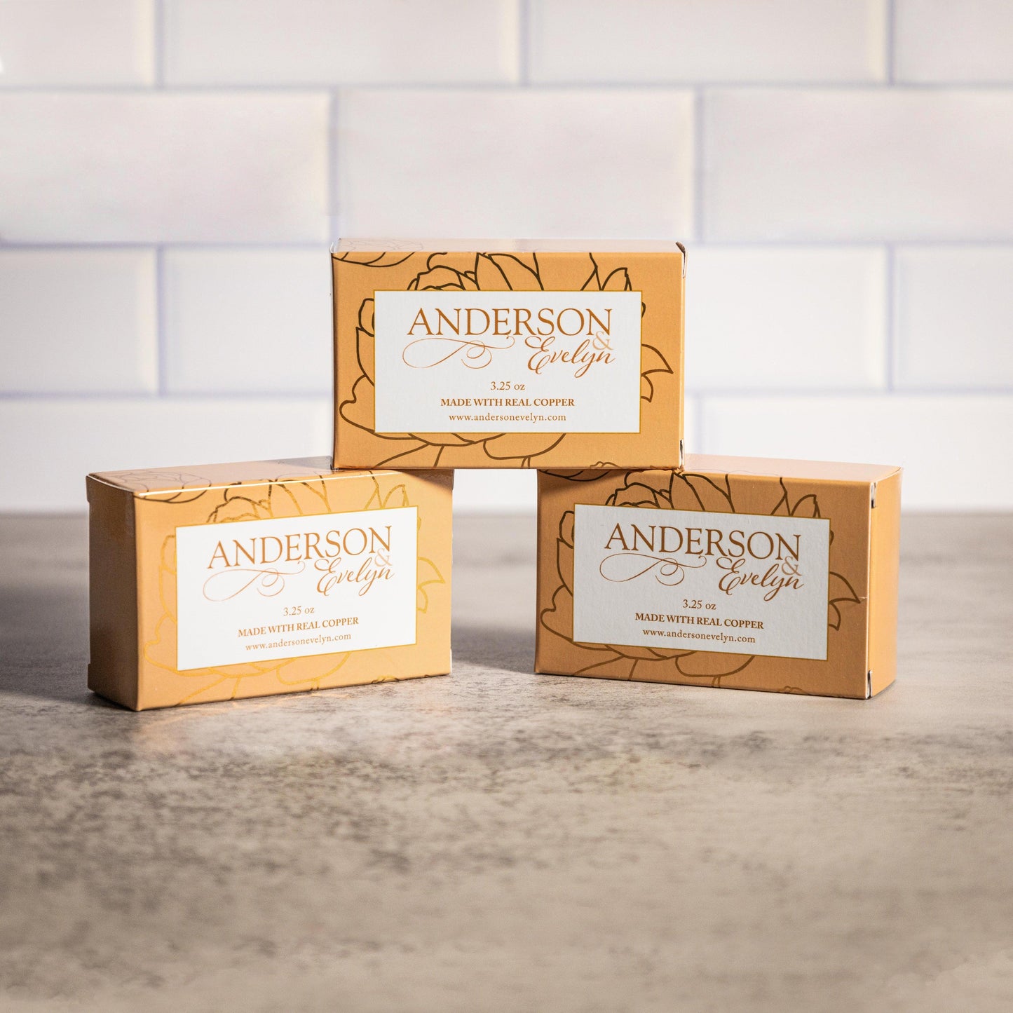 Three boxes of all-natural soap made with real copper displayed on a stone surface