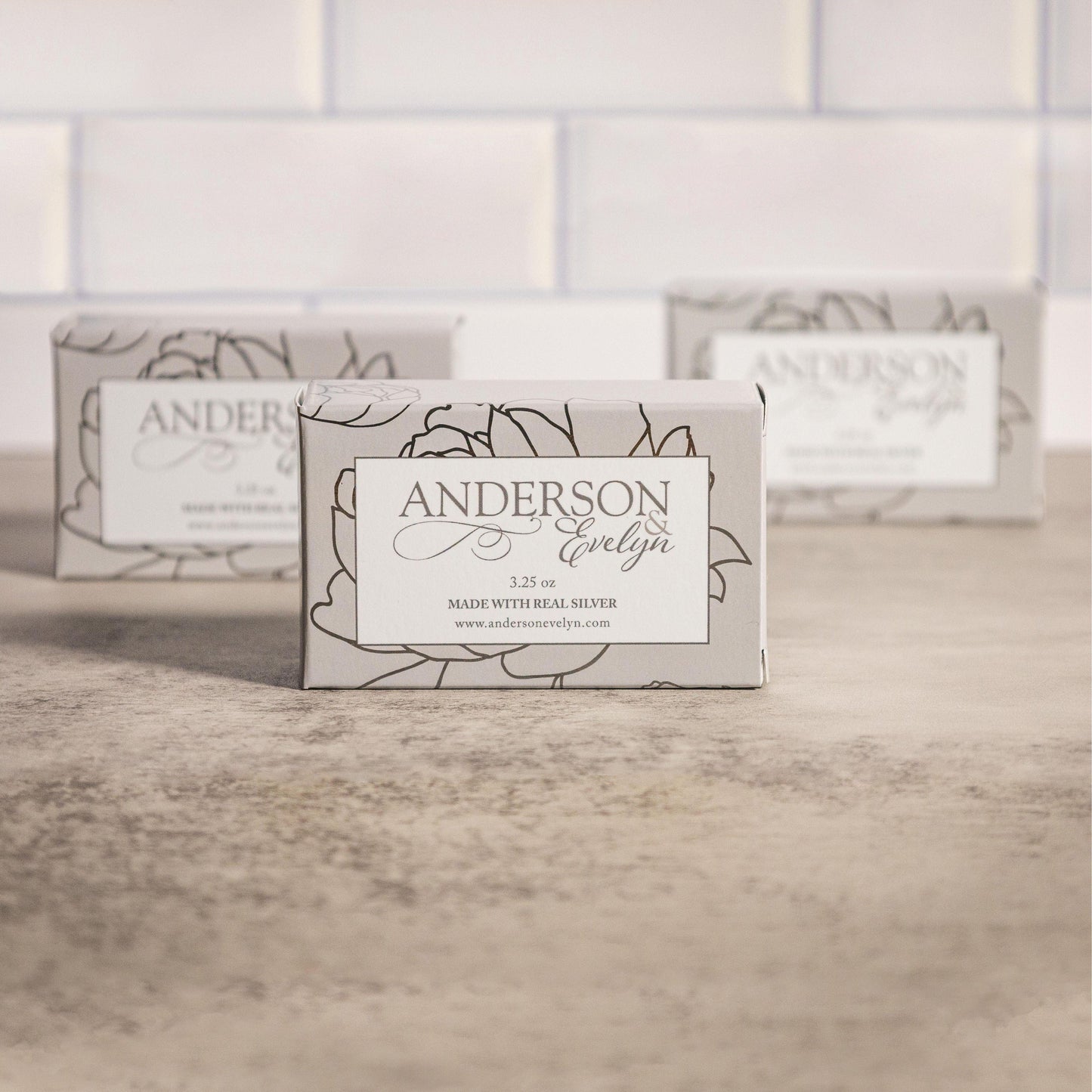 Natural bar soap with real silver ions in elegant floral packaging on a stone surface