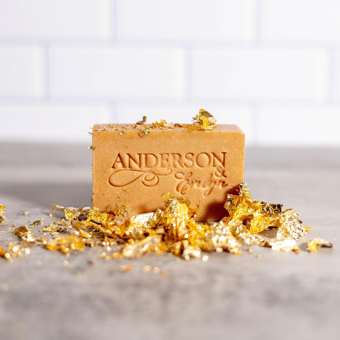 Natural soap bar with copper, silver, and gold accents on a gray countertop