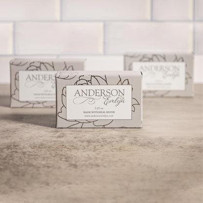 Natural bar soap with real silver ions in elegant floral packaging on a stone surface
