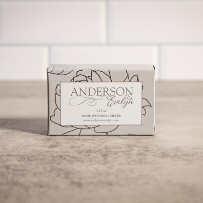Natural soap bar with real silver in floral packaging on a countertop